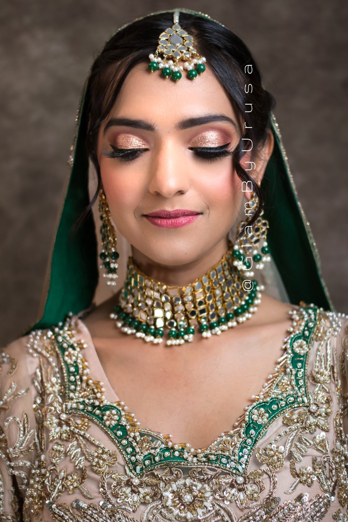 South Asian bridal makeup and hair by Glam By Urusa, with soft shimmer eyes, winged liner, maang tikka and an emerald green dupatta