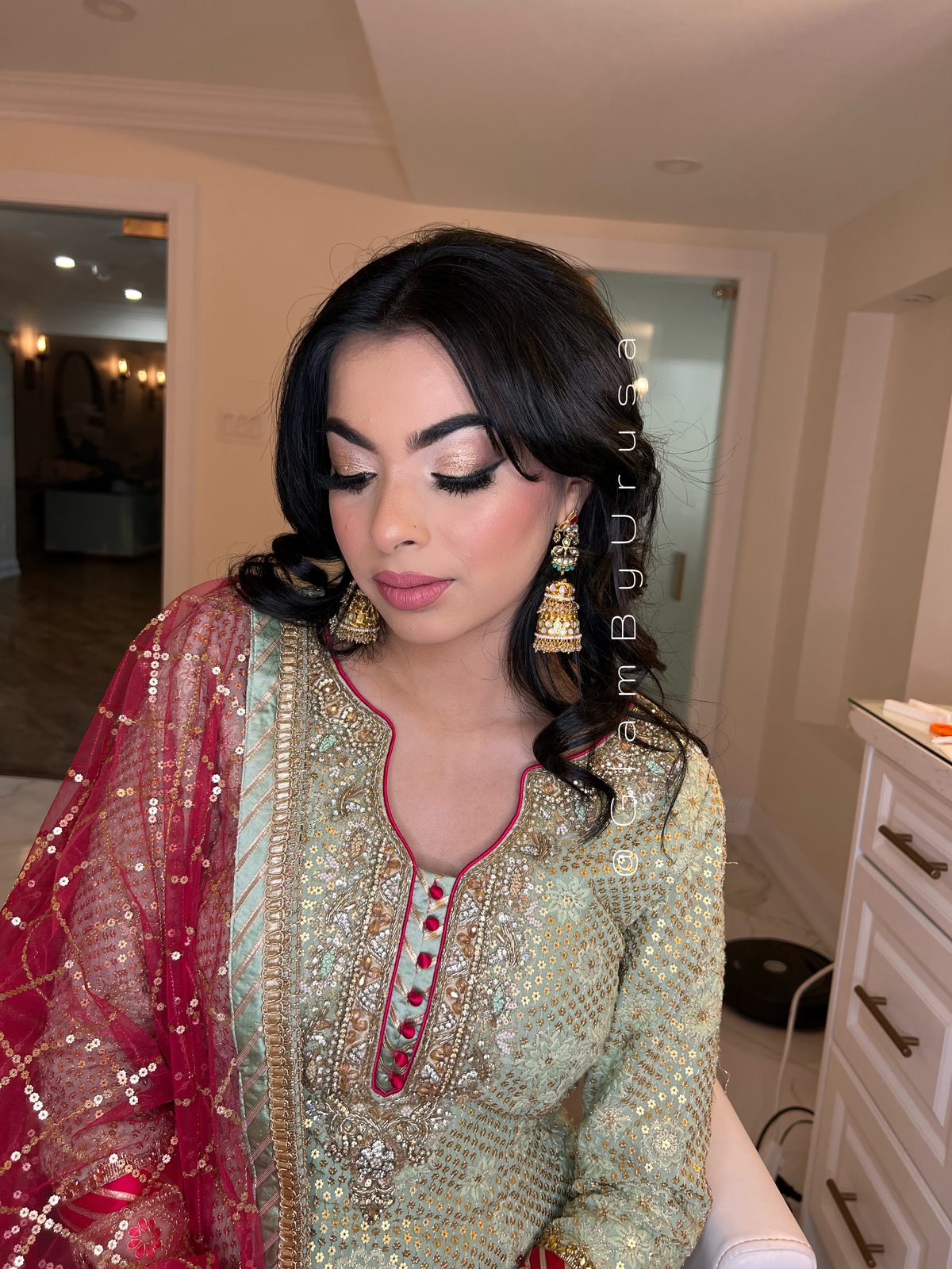 Semi-bridal makeup and soft curled hair with gold jhumka earrings for a mehndi celebration in Durham Region